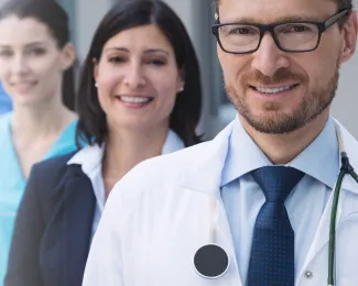 Medical professionals stand in staggered line.